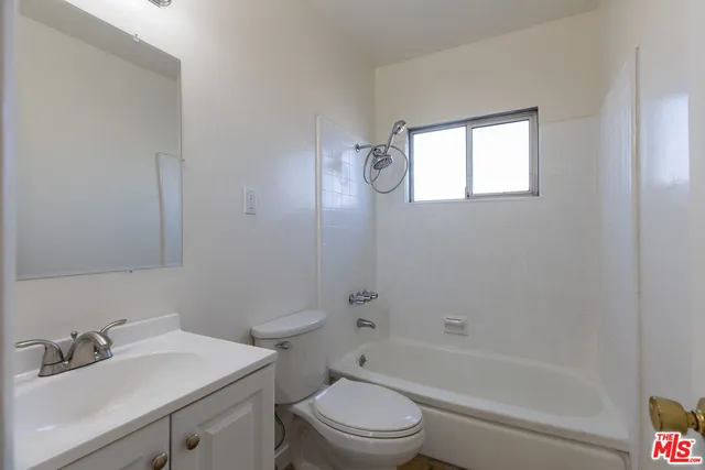 a bathroom with a sink toilet vanity and shower