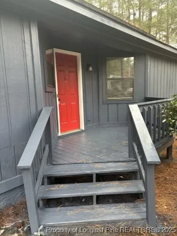 a view of a hallway with wooden floor and a kitchen