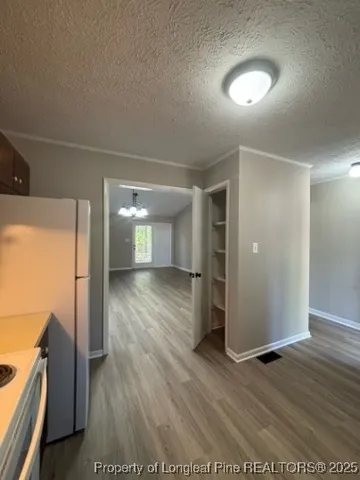 a view of a room with wooden floor ceiling fan and window