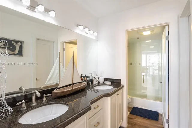 a bathroom with double vanity sinks and a mirror