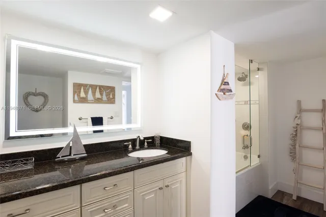 a bathroom with a granite countertop sink and a mirror