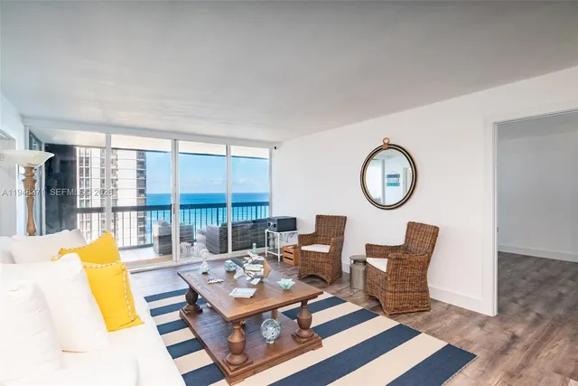 a living room with furniture a large window and a table