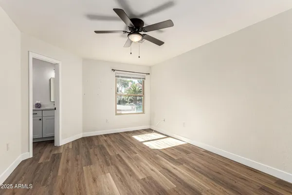 a large white kitchen with a large window a sink stainless steel appliances and cabinets