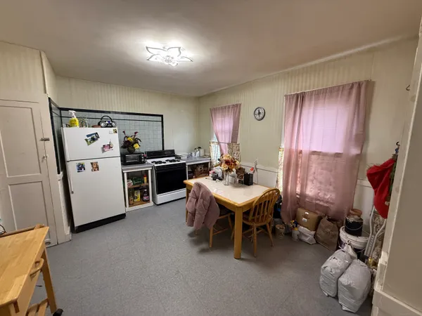 a kitchen with stainless steel appliances kitchen island granite countertop a refrigerator a sink a stove and white cabinets