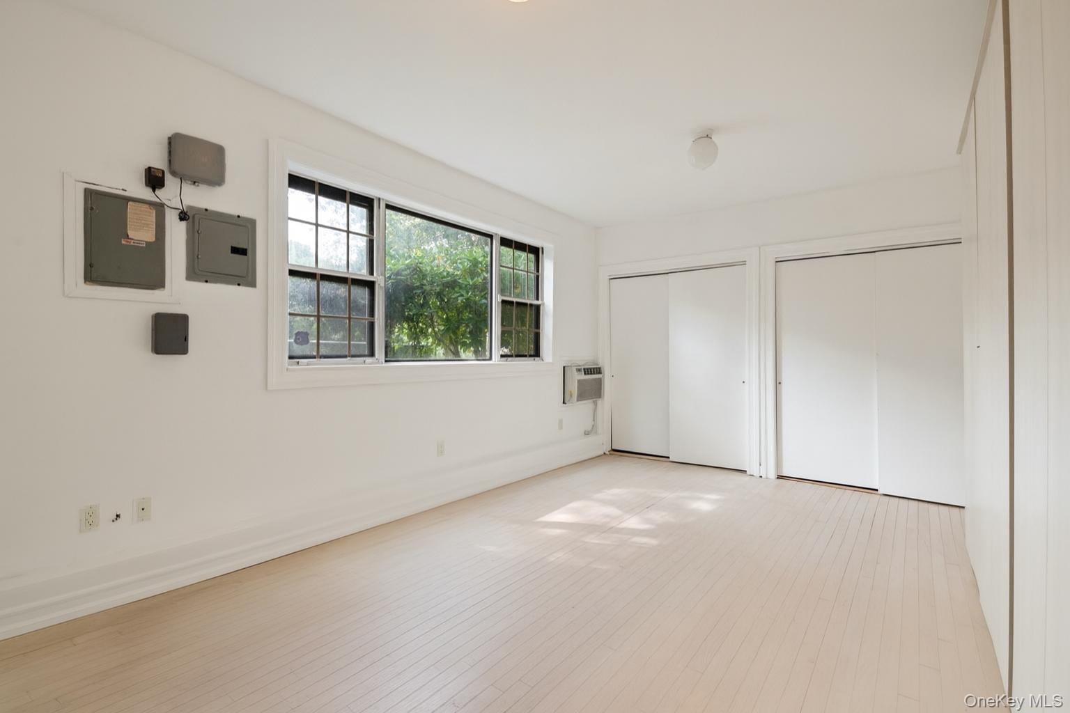 40 Nidzyn Avenue Remsenburg, NY 11960 - Photo 11 of 28 Unfurnished bedroom featuring two closets, electric panel, and wood finished floors