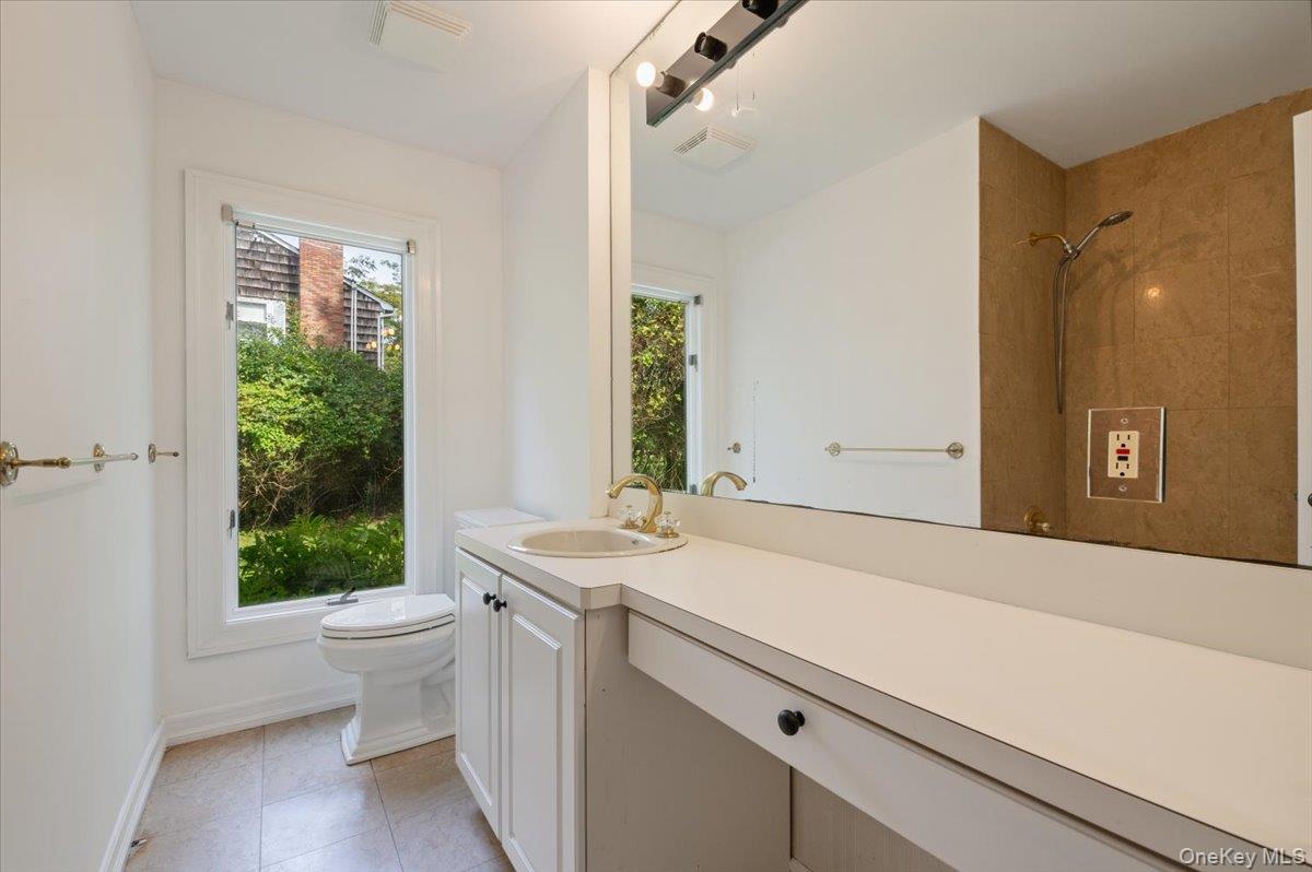 40 Nidzyn Avenue Remsenburg, NY 11960 - Photo 17 of 28 Bathroom featuring vanity, light tile patterned flooring, and tiled shower