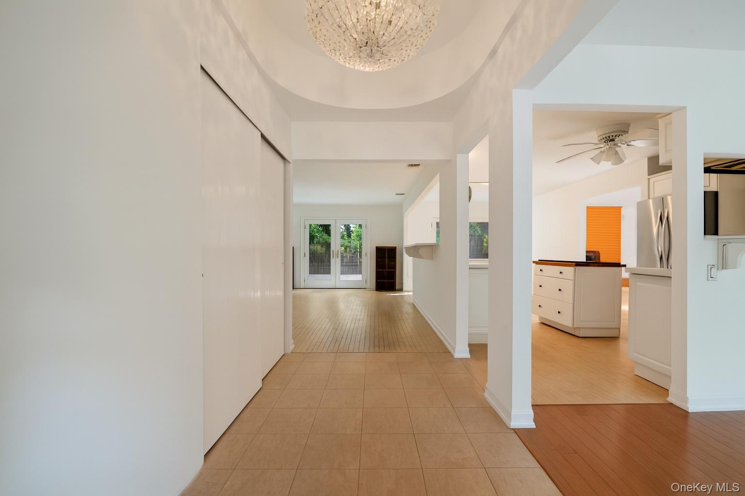 40 Nidzyn Avenue Remsenburg, NY 11960 - Photo 3 of 28 Corridor featuring light tile patterned floors and a chandelier