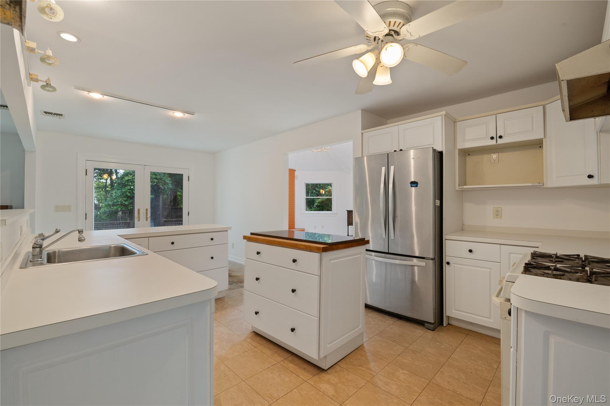 40 Nidzyn Avenue Remsenburg, NY 11960 - Photo 6 of 28 Kitchen with freestanding refrigerator, a kitchen island, white gas stove, white cabinets, and recessed lighting
