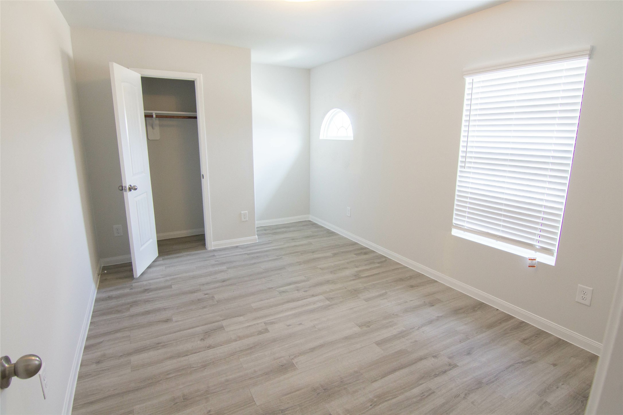 18611 Bell Ravine Drive Katy, TX 77449 - Photo 12 of 12 an empty room with wooden floor and windows