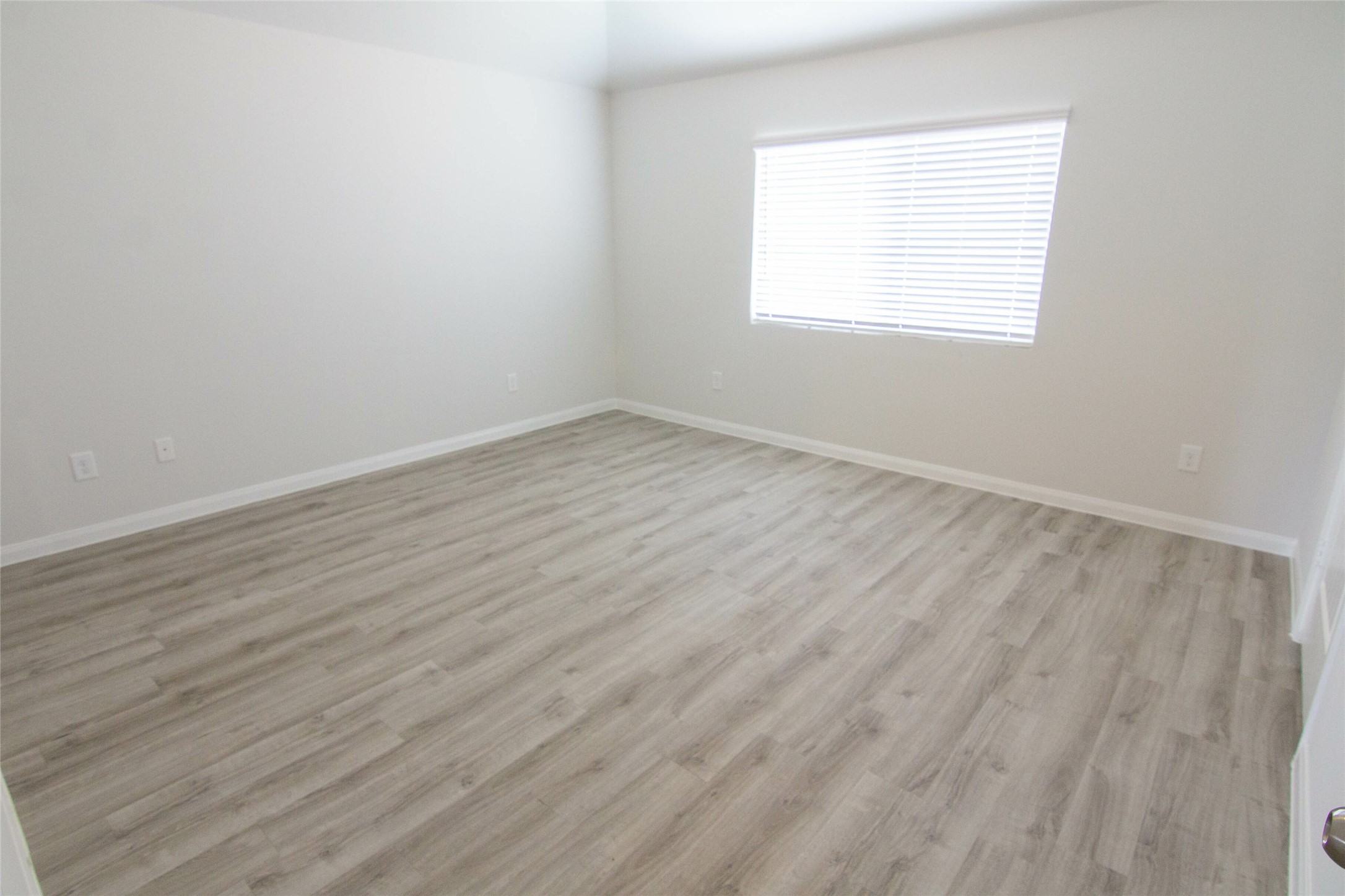 18611 Bell Ravine Drive Katy, TX 77449 - Photo 9 of 12 an empty room with wooden floor and windows