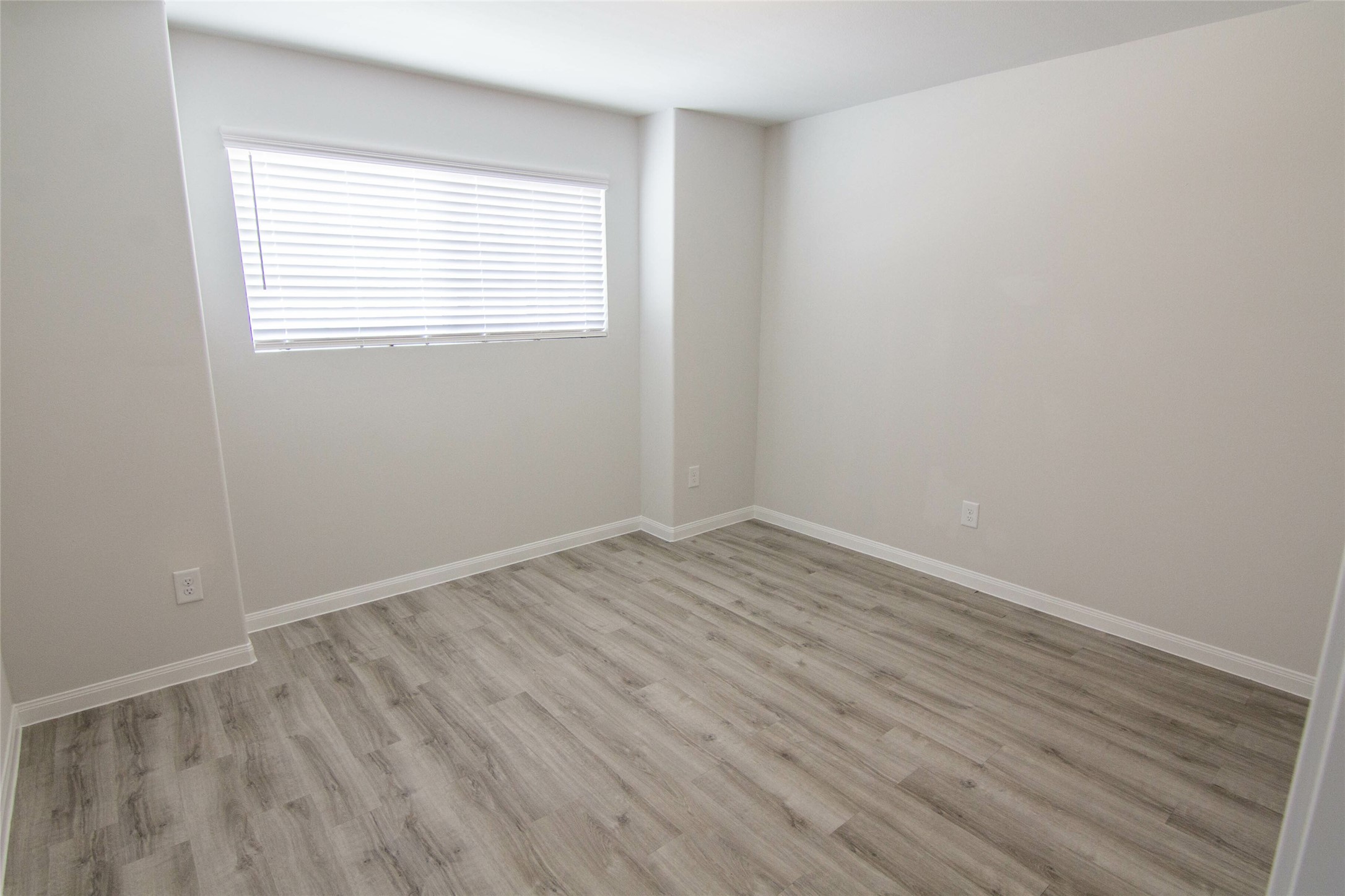 18611 Bell Ravine Drive Katy, TX 77449 - Photo 11 of 12 an empty room with wooden floor and windows