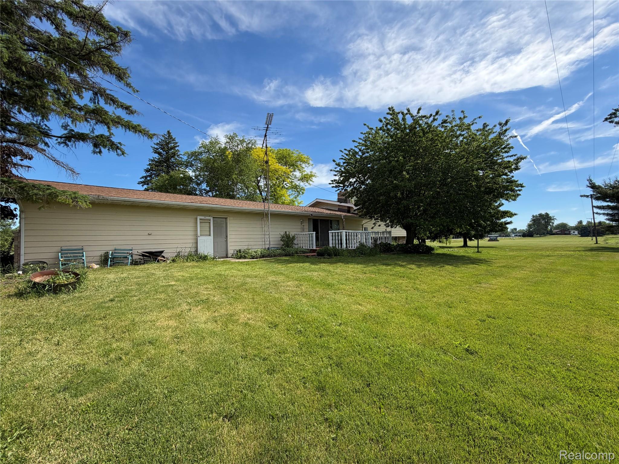 8886 East Burnside Road Brown City, MI 48416 - Photo 5 of 22 Expansive green lawn surrounds the property, featuring a beige-sided exterior with a brown roof