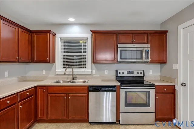a kitchen with stainless steel appliances granite countertop a sink stove and microwave