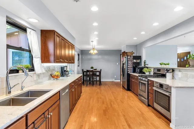 a kitchen with stainless steel appliances a sink stove and cabinets
