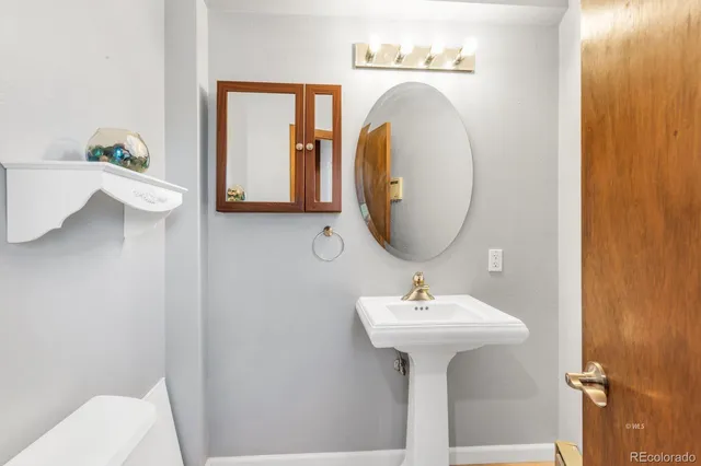 a bathroom with a sink toilet and a mirror