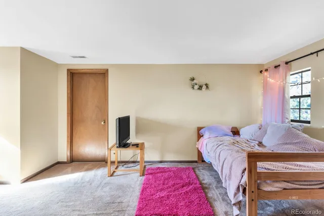 a living room with furniture a flat screen tv and a floor to ceiling window