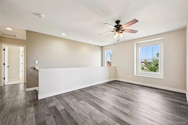 a view of an empty room with window and wooden floor