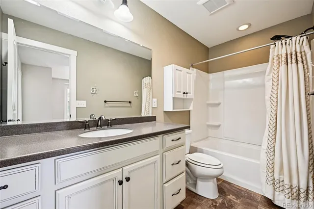 a bathroom with a granite countertop sink toilet and shower