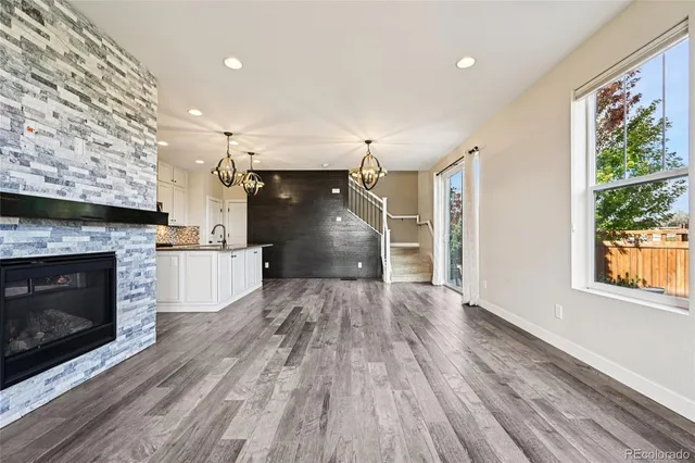 a view of empty room with a fireplace and wooden floor