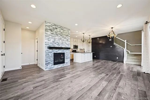 a view of empty room with wooden floor and fireplace
