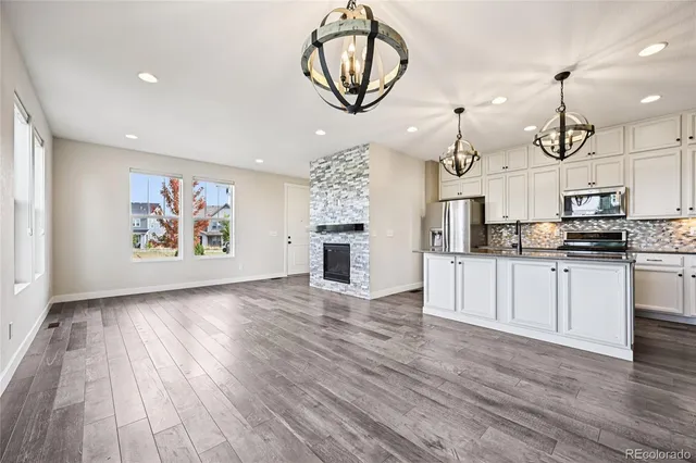 a view of a kitchen with furniture and wooden floor