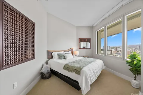 a bedroom with a large bed and a potted plant