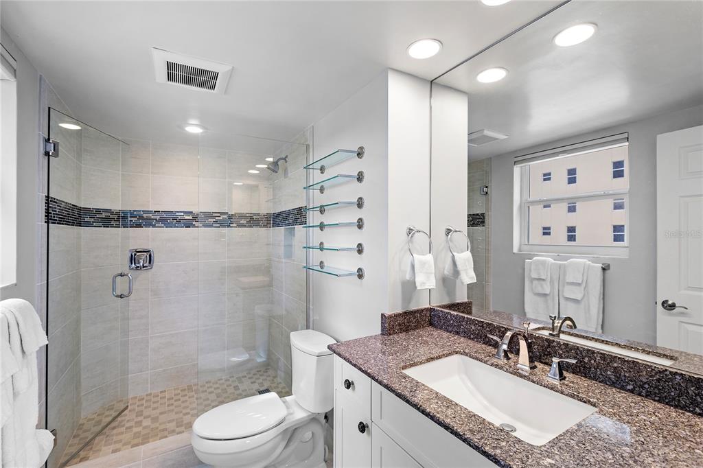 603 Longboat Club Road, Unit 304N Longboat Key, FL 34228 - Photo 16 of 43 a bathroom with a granite countertop sink a mirror a toilet and shower