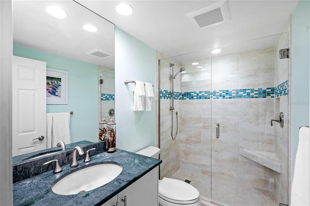 603 Longboat Club Road, Unit 304N Longboat Key, FL 34228 - Photo 20 of 43 a bathroom with a granite countertop sink toilet a mirror and shower