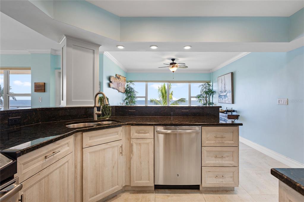 603 Longboat Club Road, Unit 304N Longboat Key, FL 34228 - Photo 10 of 43 a kitchen with granite countertop a sink and white cabinets