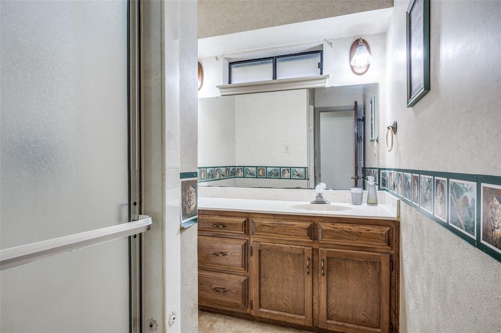508 South Pedigo Street Pilot Point, TX 76258 - Photo 20 of 25 a bathroom with a granite countertop sink and a mirror