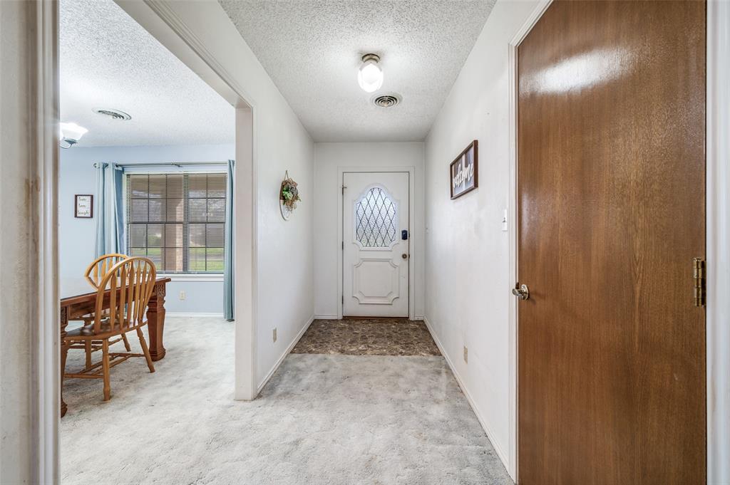 508 South Pedigo Street Pilot Point, TX 76258 - Photo 3 of 25 a view of a hallway to a livingroom with furniture and windows