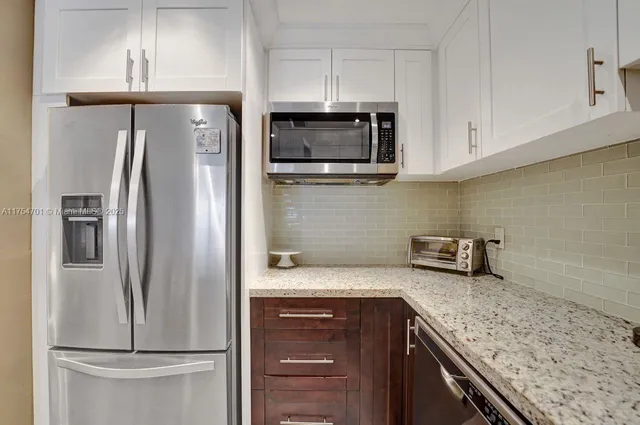 a kitchen with cabinets and wooden floor
