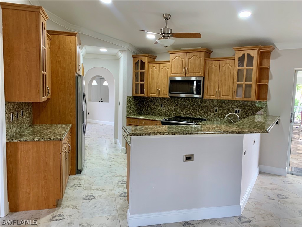 18246 Sycamore Road Fort Myers, FL 33967 - Photo 8 of 35 a kitchen with stainless steel appliances granite countertop a sink and a refrigerator