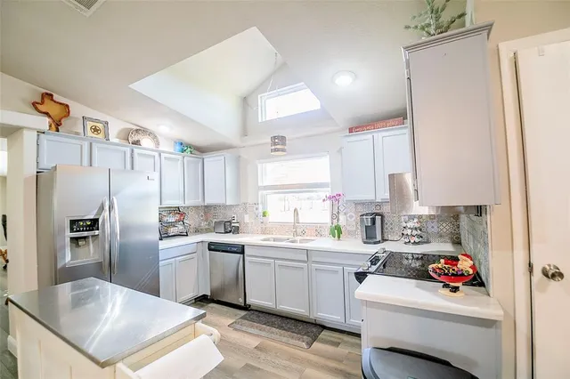 a kitchen with white cabinets and stainless steel appliances