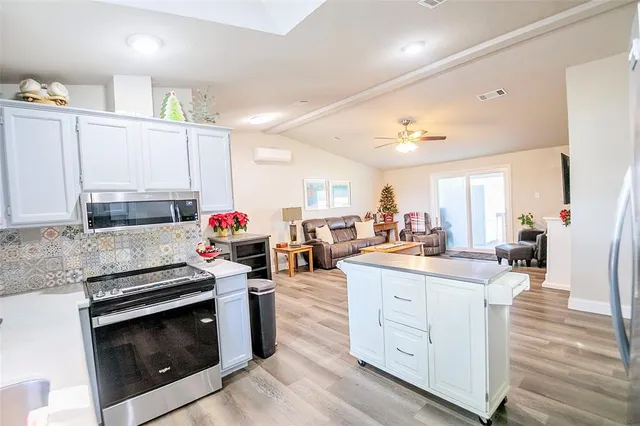 a kitchen with stainless steel appliances kitchen island granite countertop a stove and cabinets