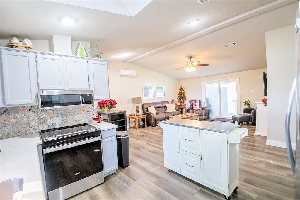 11661 Dane Road Pilot Point, TX 76258 - Photo 13 of 40 a kitchen with stainless steel appliances kitchen island granite countertop a stove and cabinets