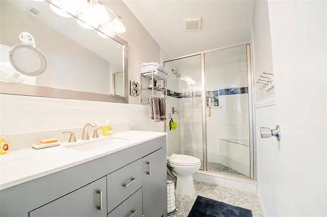 a bathroom with a sink a toilet and shower