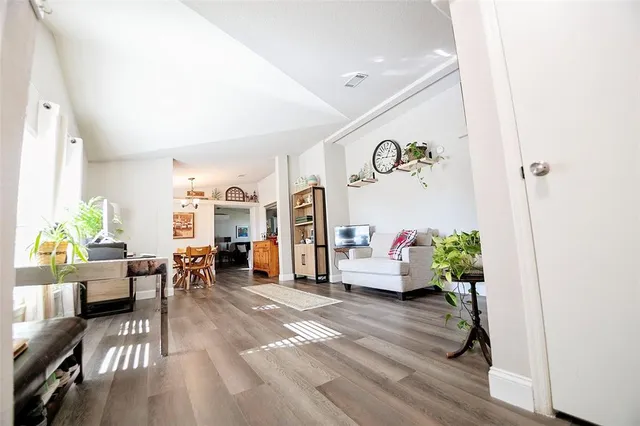 a living room with furniture and a wooden floor