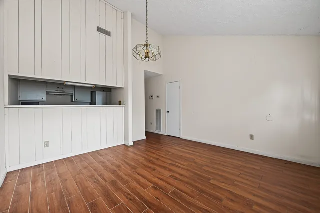 a view of a room with wooden floor and a hallway