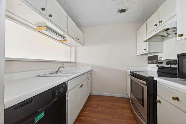 a kitchen with a sink stove and cabinets