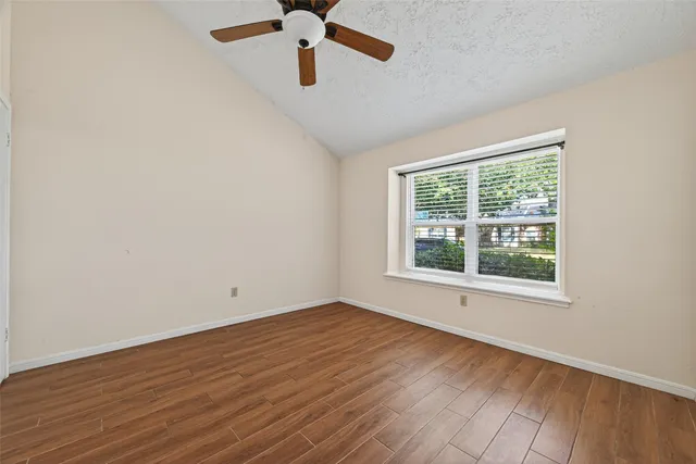 an empty room with a window and a ceiling fan