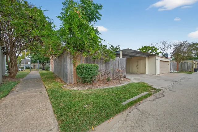 a front view of a house with a yard and a trees