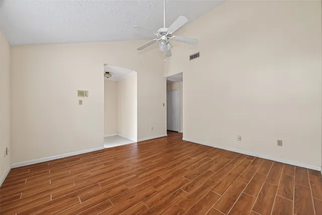 a view of an empty room with wooden floor