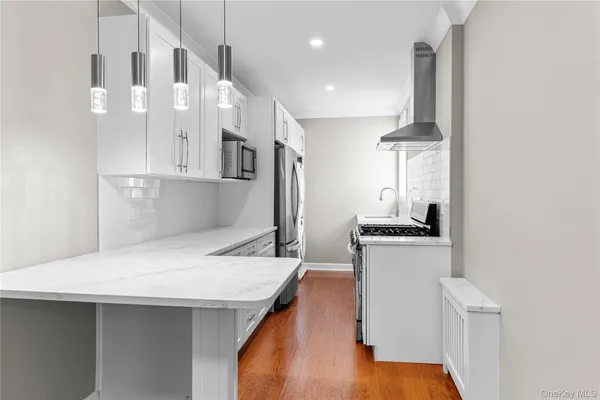 a kitchen with stainless steel appliances granite countertop a sink a stove and a refrigerator