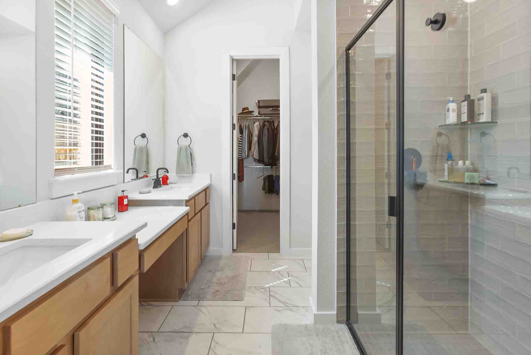 220 Basket Flower Loop Kyle, TX 78640 - Photo 18 of 40 Dual vanities and a spacious walk-in closet highlight this well-appointed primary bathroom.