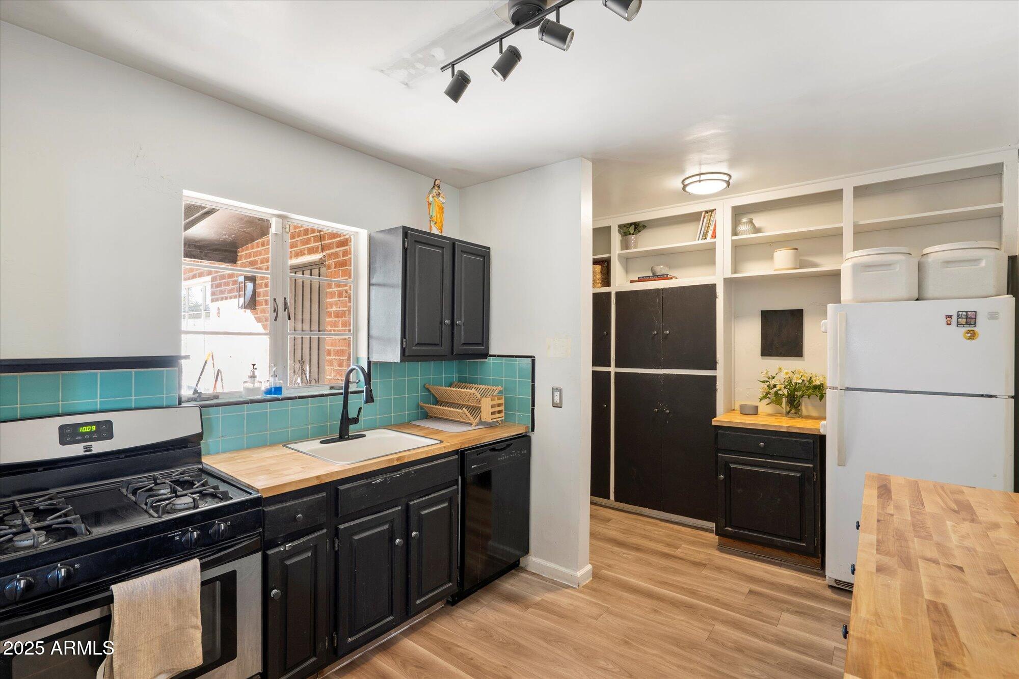 1405 East Osborn Road Phoenix, AZ 85014 - Photo 6 of 30 a kitchen with stainless steel appliances granite countertop a refrigerator and a sink