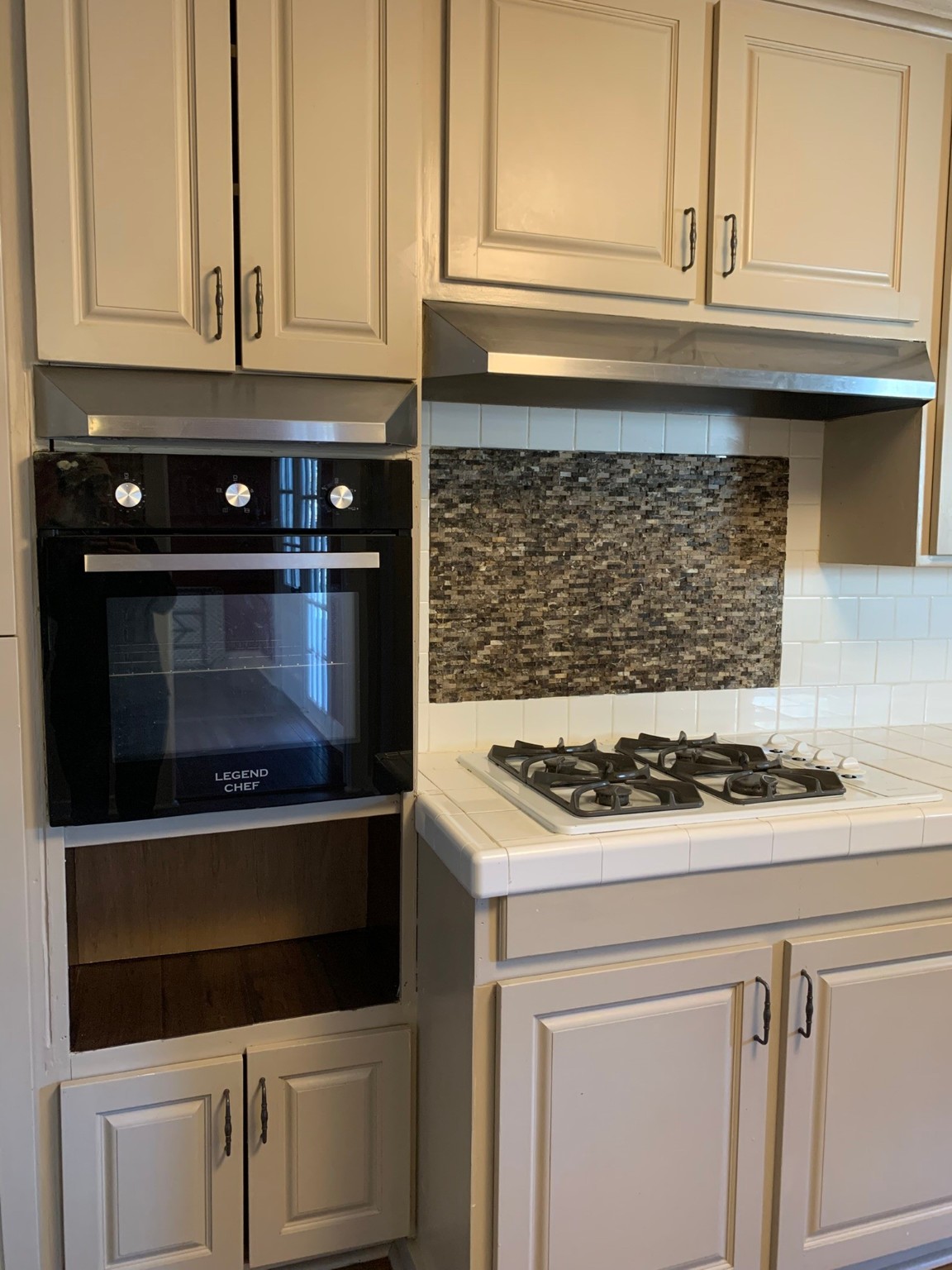 1315 Penick Road Waller, TX 77484 - Photo 7 of 13 a kitchen with white cabinets and black appliances