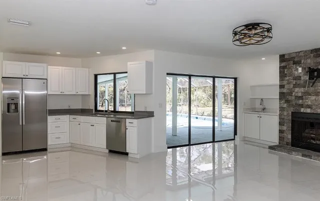 a kitchen with granite countertop white cabinets white stainless steel appliances with a sink and dishwasher