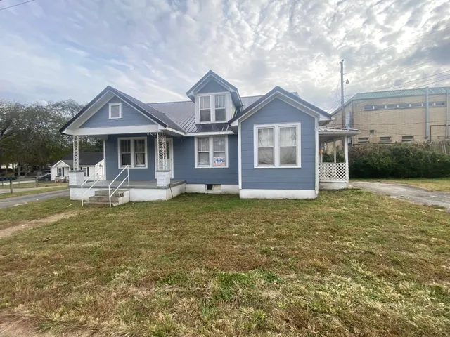 a front view of a house with a yard and lake view