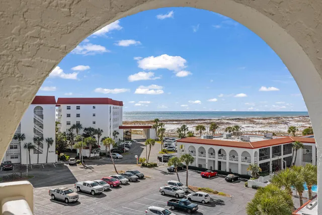a bedroom with a large bed wooden floor and a chandelier